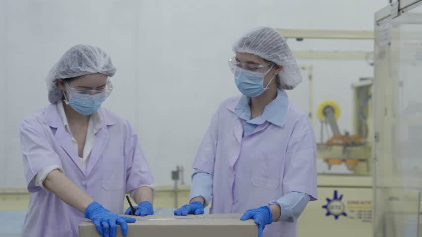 Food factory automated production line, Female factory worker protective clothing handling packaging sterile manufacturing room with mask, gloves, hairnet, teamwork, inspection, production