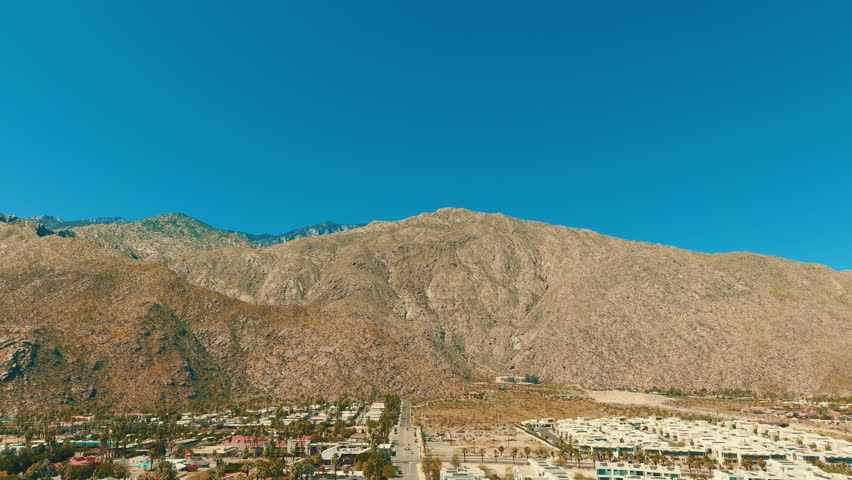 Aerial drone view of rocky desert mountain landscape near Palm Springs California under bright blue sky and sunlight