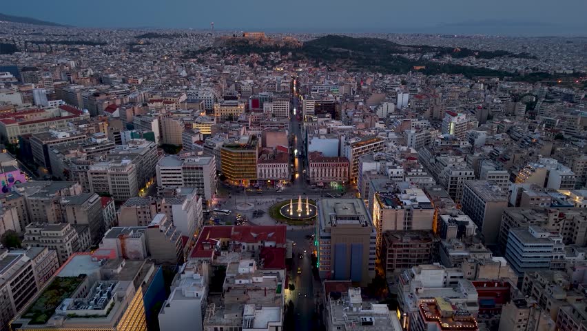 Aerial view of the city skyline of Athens, Greece, from Omonia Square following Athinas Street until the Acropolis hill during dusk