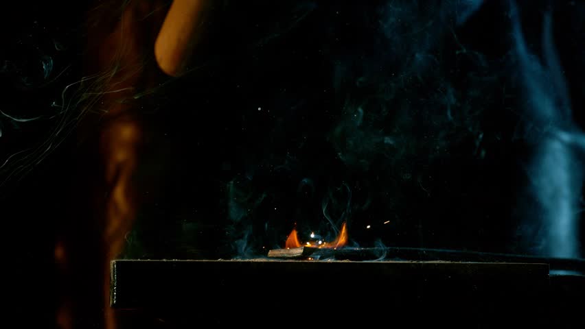 Cinematic close-up of blacksmith forging glowing hot iron on anvil with sparks flying. Shot in dramatic lighting on dark background with high-speed camera at 1000fps. Speed ramp.