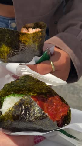 People Holding Japanese Onigiri Rice Balls Close Up 4K Vertical Video