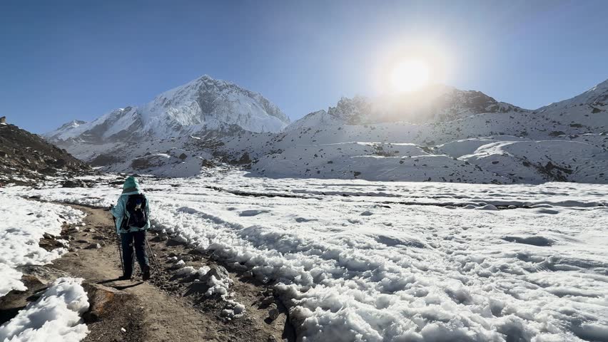 Hiker trekking toward snowy Himalayan peaks in Nepal