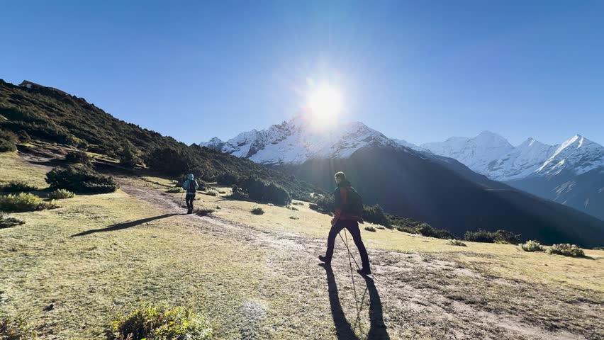 Hikers with trekking poles walking Everest Base Camp trail in Himalayas, Nepal