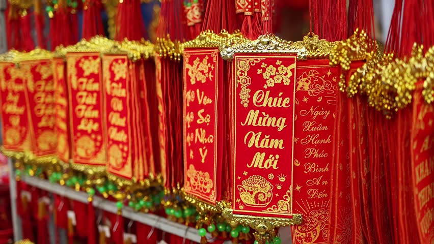 Traditional Vietnamese Lunar New Year decoration close up. Red hanging scrolls with golden Chuc Mung Nam Moi (Happy New Year) calligraphy text at a street holiday market in Nha Trang, Vietnam.
