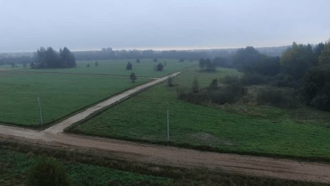Drone Flying Forward above Misty Rural Fields