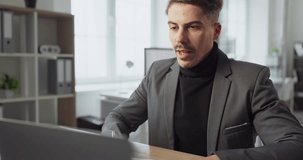 Man businessman in office on video chat call. Focused professional attends online meeting on laptop to discuss strategy and ensure strong remote teamwork. Concept of remote business teamwork. - Powered by Shutterstock - Get 15% off with code: PIKWIZARD15