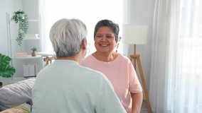 Asian senior elderly couple sitting on sofa in cozy living room at home. Loving elderly older mature man and woman enjoying retirement life together, smiliing and hugging each other in cozy house. - Powered by Shutterstock - Get 15% off with code: PIKWIZARD15