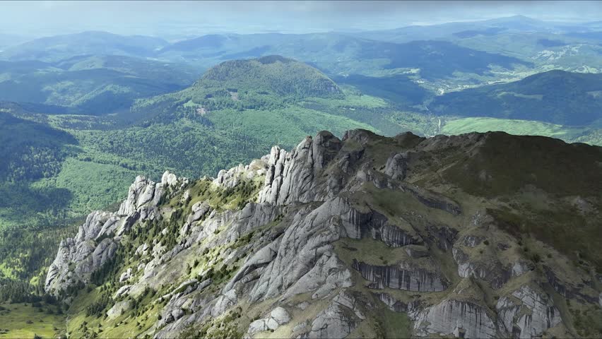 Ciucas Mountains rock spires aerial view over green valley Romania