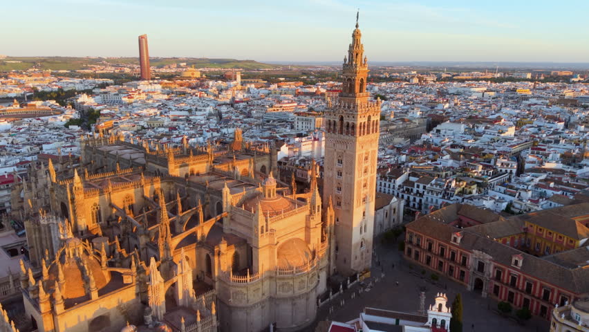 Aerial glimpse of Seville at sunset. Golden hour illuminates historic Seville city and architecture