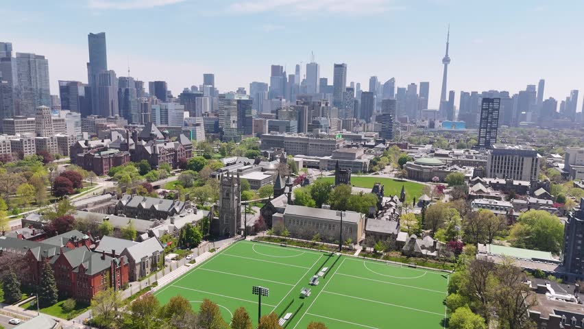 Aerial view flying straight forward over the green Back Campus field toward the historic Soldiers