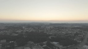 Smooth cinematic drone footage drifting sideways over a suburban cemetery before revealing a church during sunrise with misty horizon peaceful atmosphere and urban landscape - Powered by Shutterstock - Get 15% off with code: PIKWIZARD15