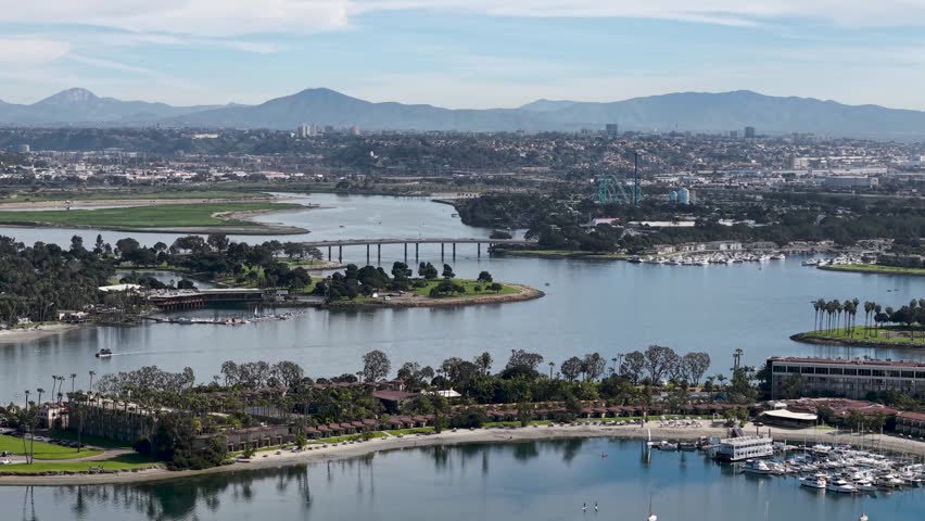 San Diego cityscape from Mission Bay. View of the bay to the full downtown city skyline and neighborhoods, California. Sea World Theme Park Rollercoasters.