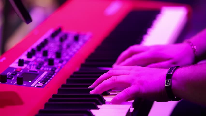 Musician hands playing electronic synthesizer keyboard on stage close up