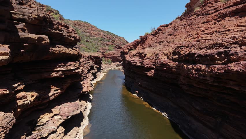 Aerial View of Z Bend Red Rock Canyon With Meandering Murchison River and Rugged Cliffs Under Clear Blue Sky, Kalbarri National Park, Western Australia.
