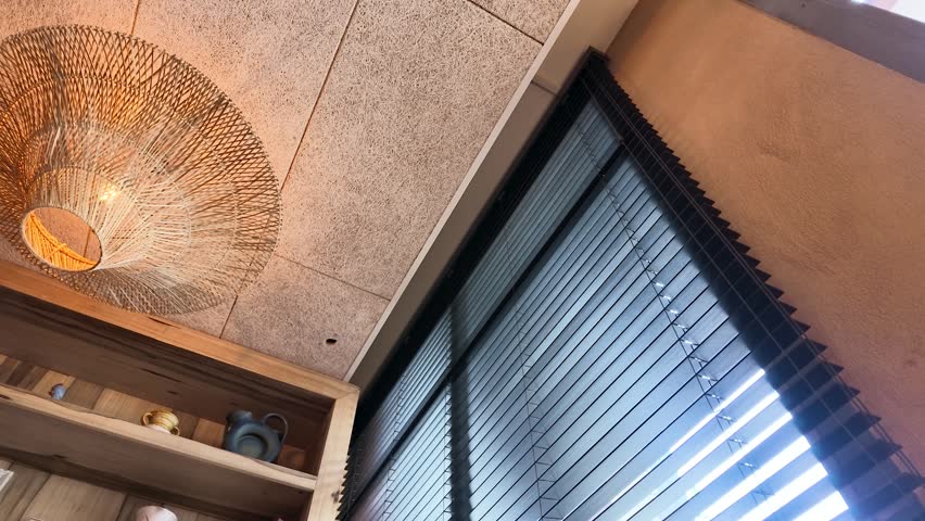 Low angle shot of a bamboo chandelier illuminating a modern interior with acoustic ceiling panels