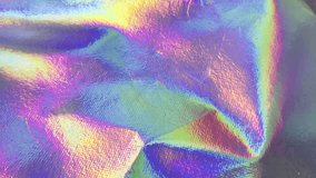 A mesmerizing close-up of a holographic foil surface, showcasing a dynamic interplay of iridescent colors and light reflections, creating a vibrant and abstract background. - Powered by Shutterstock - Get 15% off with code: PIKWIZARD15