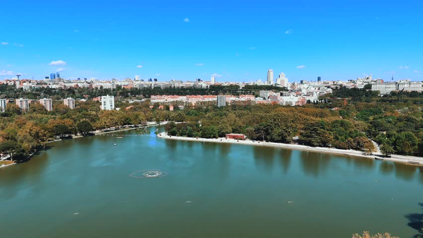 Wide aerial panorama of lake and Madrid skyline under clear sky