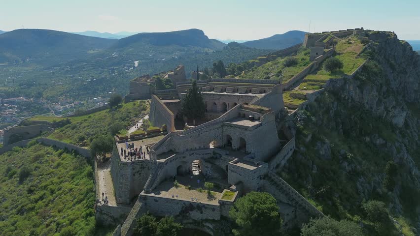Cinematic 4K drone panning shot left over the historic Palamidi Fortress in Nafplio, Greece. Imposing Venetian medieval castle structures built on a rugged hill. UNESCO world heritage style.