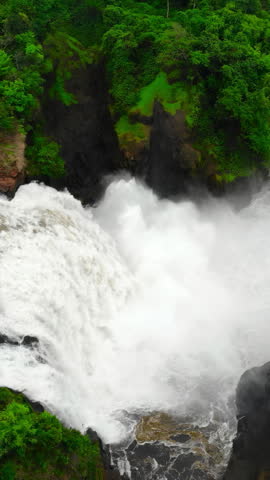 Impressive Natural Waterfall Pouring Into Rocky Basin With Roaring Sounds And Mist Rising Above. Media
