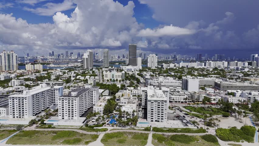 Aerial skyline of Miami Beach, Florida at sunset with bay, highrise buildings and dramatic clouds. g.