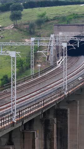 High-speed train crosses a bridge and enters a tunnel. Italy.
Aerial view of a train through the Roman countryside.