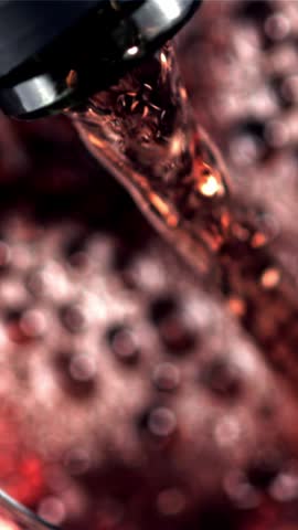Super slow motion red wine pours with air bubbles into the glass. Macro background. Top view.Filmed on a high-speed camera at 1000 fps. High quality FullHD footage