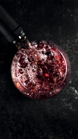 Super slow motion red wine pours into a glass of air bubbles. On a black background.Filmed on a high-speed camera at 1000 fps. High quality FullHD footage