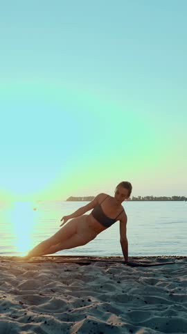 Barre workout. stretching outdoors. yoga beach. Athletic young woman is doing exercises on mat, at the beach during sunset or sunrise. Fitness training outdoors. Fitness, ballet, sport, yoga