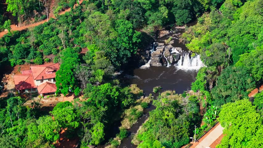independent house with trees, road and Kote Abbey Waterfalls at mukkodlu, coorg, karnataka, india. day time, semi orbit shot, drone shot, 4k.