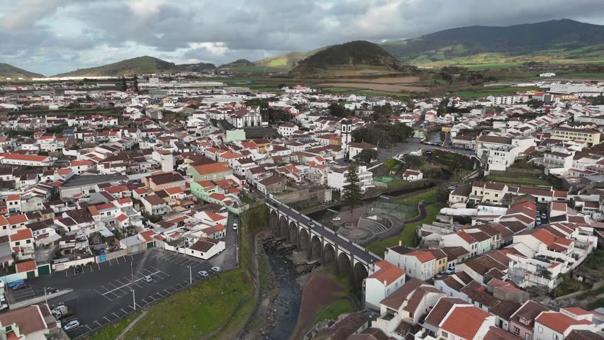 aerial drone shot over the rooftops and streets of Ribeira Grande, Sao Miguel, Azores. Traditional white buildings and red roofs of a Portuguese island town near the Atlantic coast