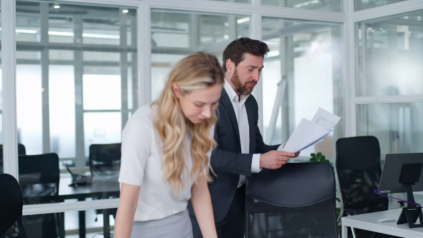 Caucasian mature businessman boss angry aggressive yelling talking to businesswoman business partners problem documents mistake bad results intern woman suffering man yell talk scolding in office