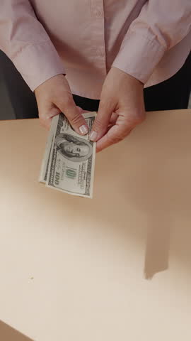 An unrecognizable woman counts American dollar bills close-up.