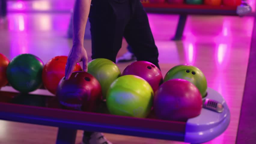 Bowling club play, group team of friends and colleagues playing, throwing a ball on the bowling alley lane, ball and pins, corporate party event in a mall amusement game center, tournament competition