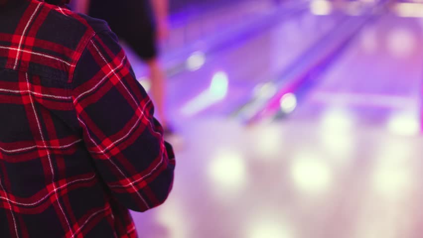 Bowling club play, group team of friends and colleagues playing, throwing a ball on the bowling alley lane, ball and pins, corporate party event in a mall amusement game center, tournament competition