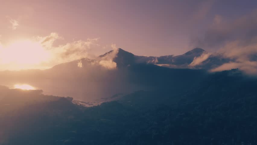 Aerial view of mountain and lake on beautiful sunrise at daytime on sunlight. Camera is moving left
