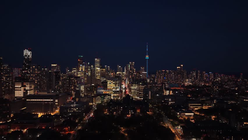 Luminous cityscape of Toronto, Ontario, Canada with illuminated buildings, downtown skyline, urban streets, modern architecture, iconic CN Tower at night