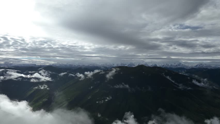 Aerial footage landscape of foggy snow capped mountains in sichuan, China, Time lapse	