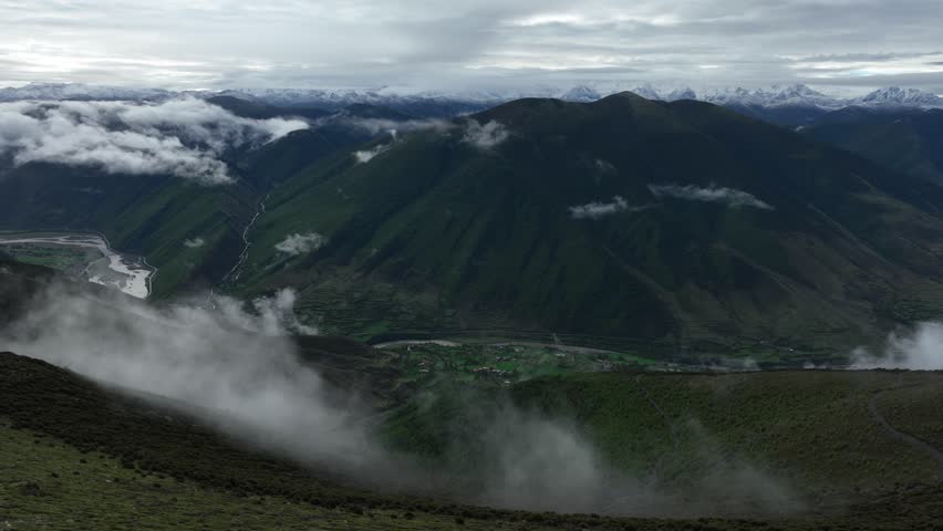 Aerial footage landscape of foggy snow capped mountains in sichuan, China	