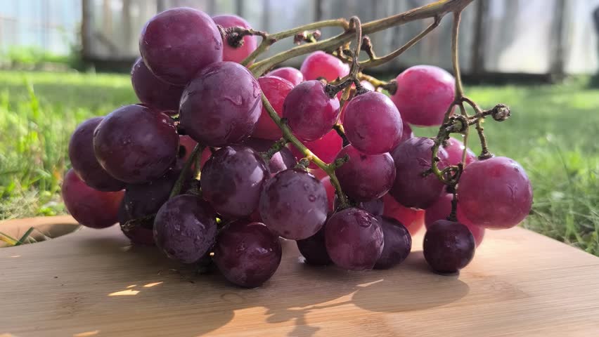 Beautiful juicy pink grapes on a cutting board