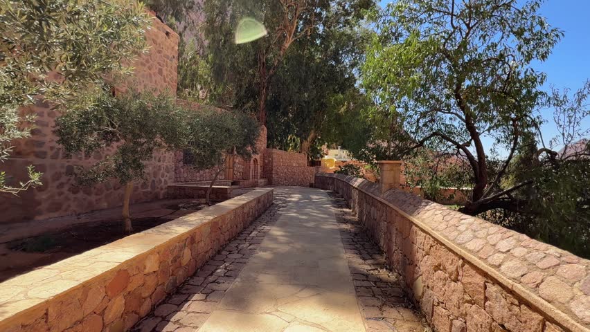 Pov walk along stone path inside Saint Catherine Monastery courtyard