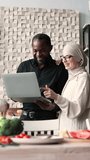 A man and a woman of diverse backgrounds collaborate on a laptop in a modern kitchen setting with fresh ingredients on the table - Powered by Shutterstock - Get 15% off with code: PIKWIZARD15