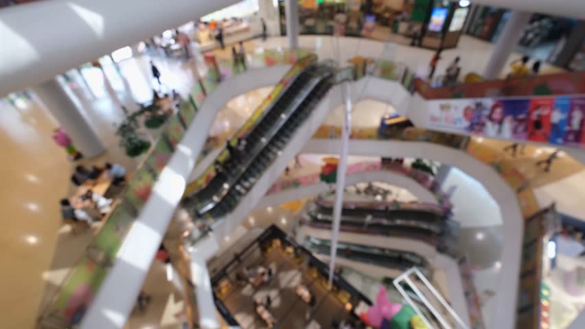 Shopping mall interior with escalator and walkway modern shopping mall, bright blurred public space and busy retail level, shopping mall interior with escalator and blurred crowd bright modern atrium