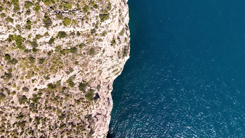 Aerial view of Spain’s rocky coast and clear blue ocean waters.