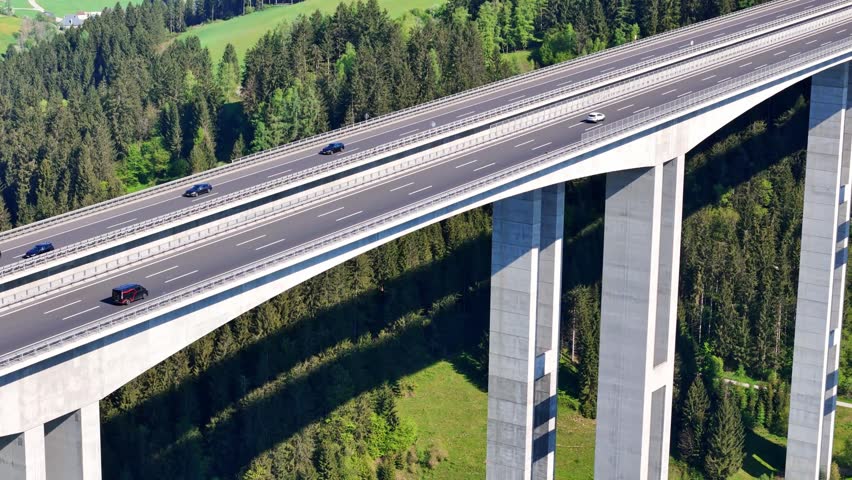 Aerial view of the Lavanttal bridge with cars driving across concrete pillars over a dense green forest in the valley Wolfsberg, Carinthia, Austria.