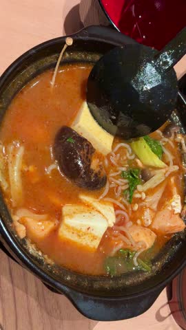 Spicy Salmon Jjigae Korean Stew with Tofu and Enoki Mushroom in Stone Pot, Hot Asian Soup