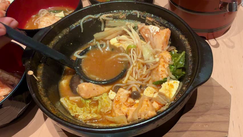 Spicy Salmon Jjigae Korean Stew with Tofu and Enoki Mushroom in Stone Pot, Hot Asian Soup