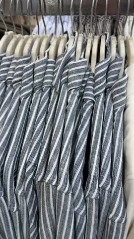Striped shirts on hangers in a clothing store, suitable for retail or fashion background video