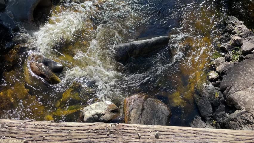 River water rushing under a bridge around rocks