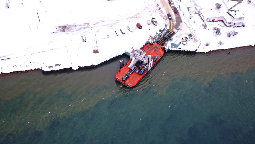 Drone shot of a river ferry carrying cars and people between Sugar Island and northern Michigan.
