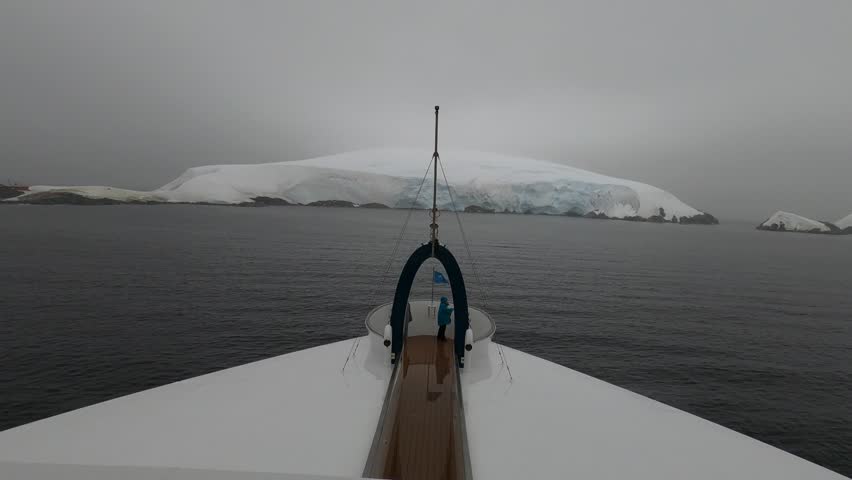 Antarctic expedition ship anchored near icy islands in Melchior archipelago, Antarctica